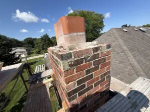 brick chimney with repointed mortar joints seen from the roof