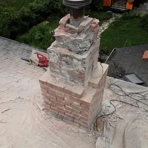 Chimney rebuild in progress with damaged upper brick removed down to sound masonry