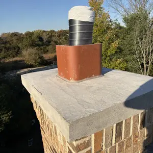 Metal vent termination above the concrete crown of a masonry chimney after a STUV 6 insert installation in Hawthorn Woods