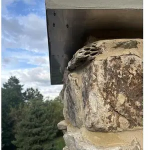 Close-up of repaired mortar joints in natural stone below the new crown overhang