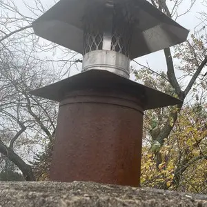 Stainless-steel cap installed on top of a utility flue liner on a masonry chimney in Mundelein