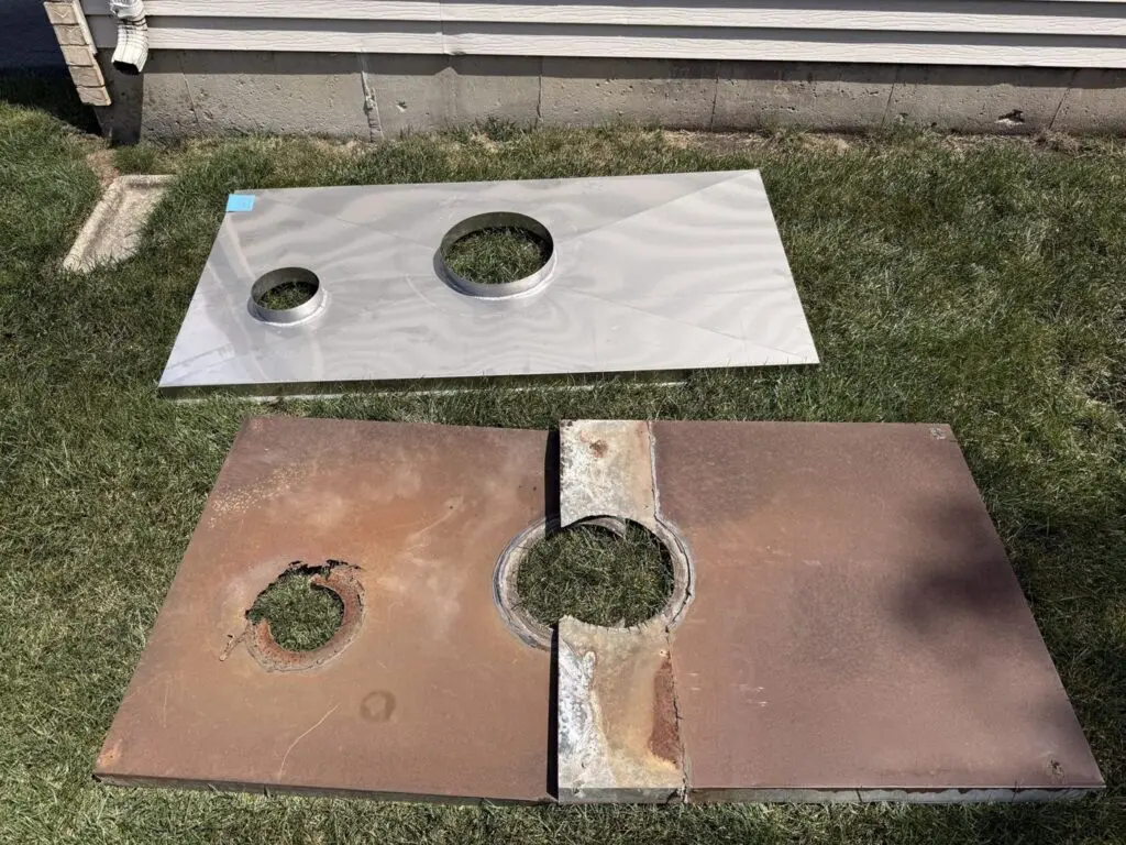 Old rusted steel chimney chase top with a corroded flue opening beside its replacement, a one-piece stainless steel chase top with two welded collars