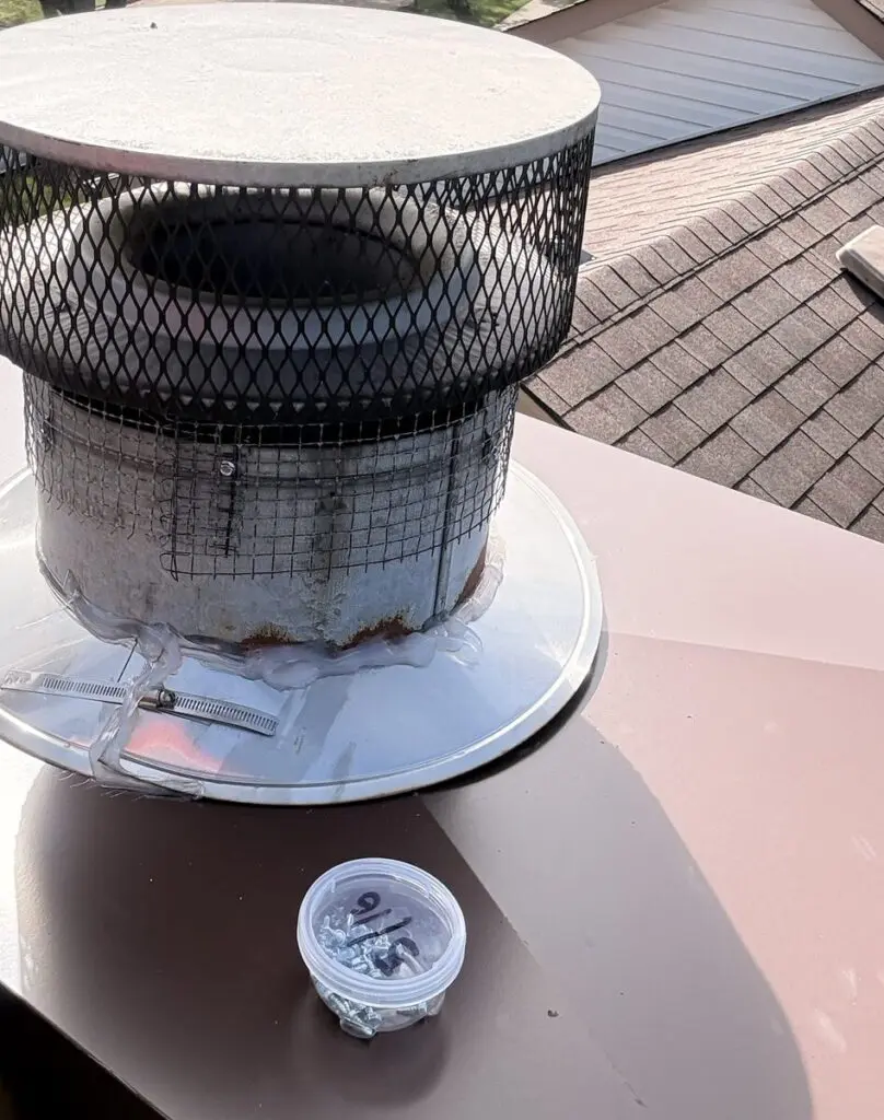 Stainless chimney liner cap with mesh spark screen and storm collar on a new chase cover